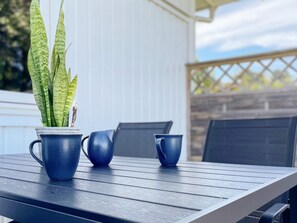 A patio table with a potted plant, two matching blue cups, and a chair. - 3 Person Holiday Home in Ronnang (Roennaeng)