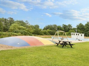 A playground with a colorful slide, swings, and a picnic table.