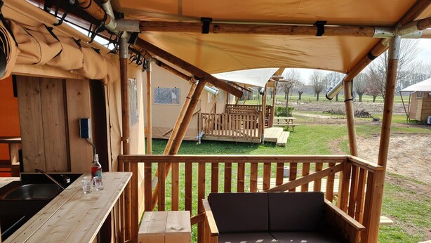 Une terrasse en bois avec un canapé et un coin bar.