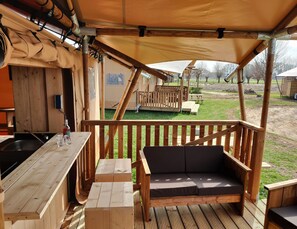 A wooden deck with a sofa and a bar area. - Forest-edge Glamping Tent (Bant)
