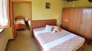 Ein Schlafzimmer mit einem hölzernen Bett, einem Kleiderschrank und einem Deckenventilator.