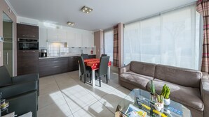 Een modern appartement met een eethoek, keuken en woonkamer.