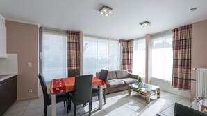 Een moderne woonkamer met een eettafel, bank en salontafel.