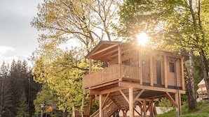 A wooden cabin with a balcony and stairs, surrounded by trees and a clear sky. - Beautiful Tree House in the Gailtal Valley (Kotschach-Mauthen)