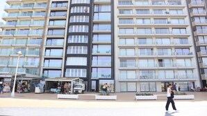 A multi-story hotel with balconies, a central courtyard, and outdoor seating areas. - Apartment in Nieuwpoort by the Beach (Nieuwpoort)