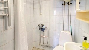 A small bathroom with a shower, toilet, and sink. - 4 Person Holiday Home in Granna (Gränna)