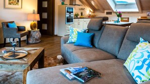 A cozy living room with a sofa, a coffee table, and a dining area with a table and chairs. - Apartment in Garmisch-partenkirchen (Garmisch-Partenkirchen)