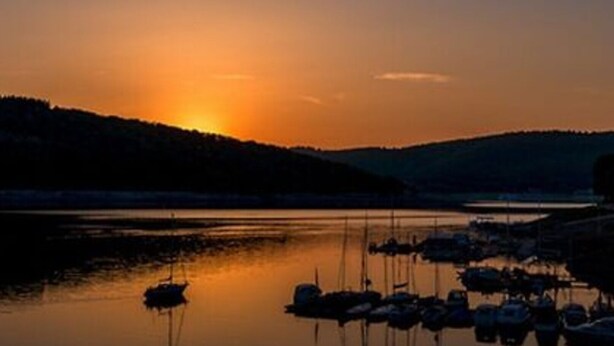 Marina com barcos atracados ao pôr do sol.