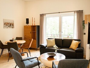 Relax in this inviting living room with a comfortable sofa, dining area, and large window.
