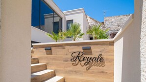 A modern building with a wooden staircase leading to a balcony. - Apartments Villa Royale - One Bedroom Apartment With Sea View (Konavle)