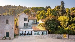 Un bâtiment en pierre doté d’un balcon, d’une piscine et offrant une vue sur la mer.