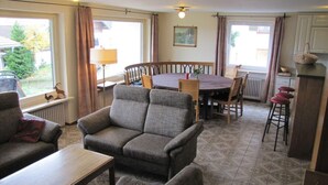 Ein gemütliches Wohnzimmer mit einer Couch, einem Couchtisch und einem Essbereich mit Tisch und Stühlen.