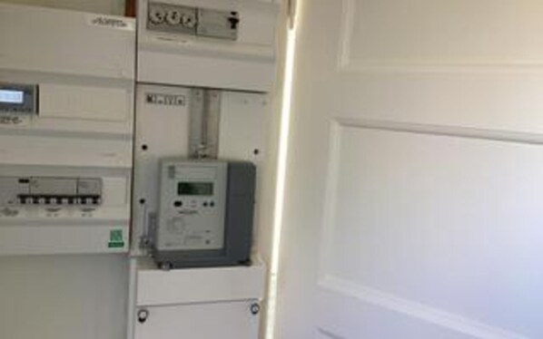 Un armario de contadores con paneles eléctricos y una pantalla digital.