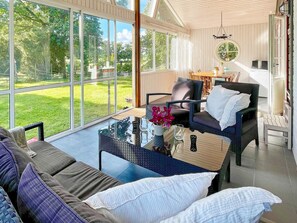 Una habitación amplia con un gran ventanal, un sofá cómodo, una mesa de comedor y una silla.