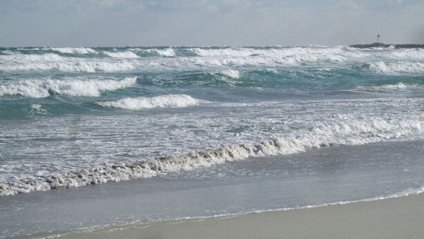 A beach with waves and a lighthouse in the distance. - Casa Felicita Comfortable Holiday Residence (San Teodoro)