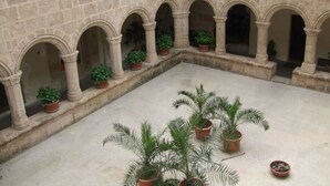 A courtyard with stone arches and potted plants. - Casa Felicita Comfortable Holiday Residence (San Teodoro)