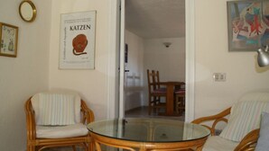 A room with wicker furniture, a glass table, and a framed poster on the wall. - Casa Felicita Comfortable Holiday Residence (San Teodoro)
