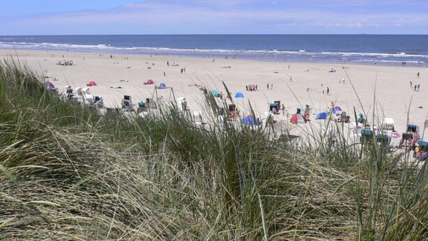 A beach with tents and beachgoers. - - Exclusively Restored Gulfhof (Wangerland)