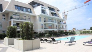 A modern hotel with a rooftop pool, multiple balconies, and a construction crane in the background. - Apartment in Nieuwpoort With sea View (Nieuwpoort)