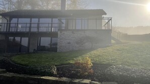 A modern house with a stone facade, large windows, and a balcony. - Holiday Home Huus Adele (Holzminden)