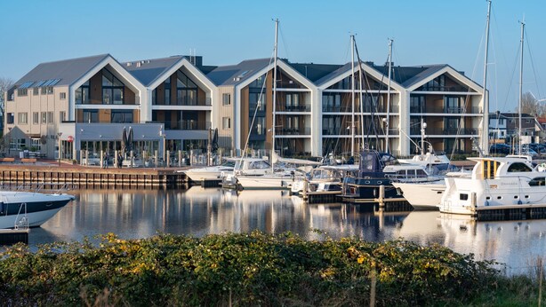 A marina with modern buildings and boats docked. - Stylish Marina Loft W/balcony (Kamperland)