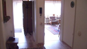 A hallway leading to a living room with a patterned rug, a chair, and a radiator. - Huis Becker-schmidt, St. Blasien (St. Blasien)