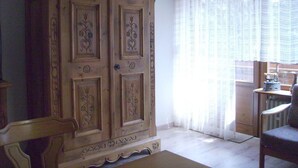A room with a large wooden wardrobe, a chair, and a window with sheer curtains. - Huis Becker-schmidt, St. Blasien (St. Blasien)