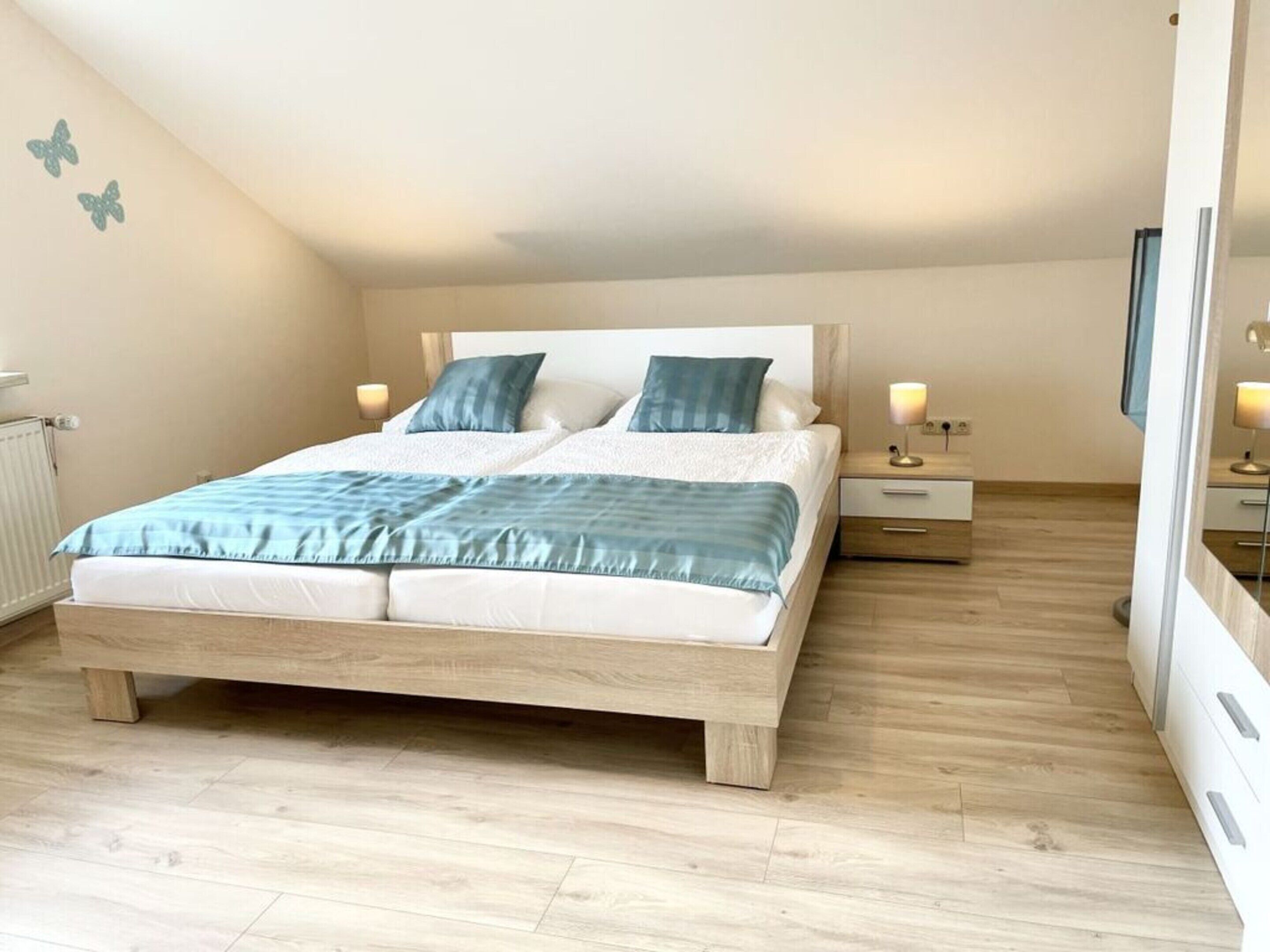 Ein Schlafzimmer mit einem hölzernen Bett, zwei Nachttischen und einem Beistelltisch.