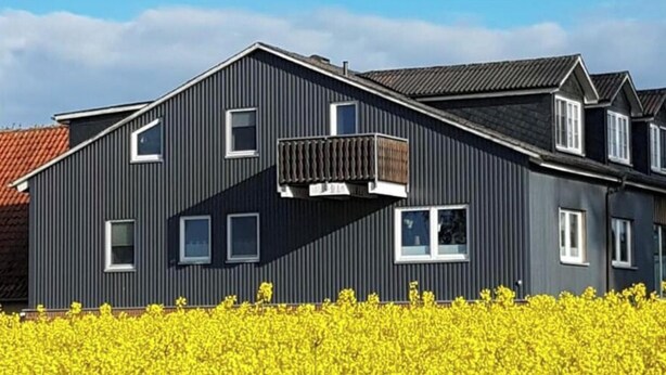 A modern two-story building with a dark facade and multiple windows. - Apartment in Rieseby (Rieseby)