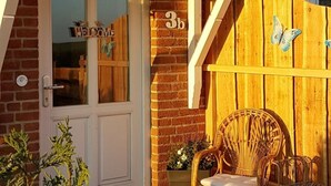 A wooden fence with a butterfly decoration, a door with a 'WELCOME' sign, and a number '3b' on the wall. - Apartment in Rieseby (Rieseby)