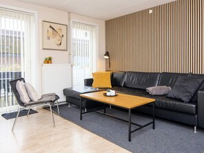 A modern living room with a sofa, a coffee table, a chair, and a radiator.