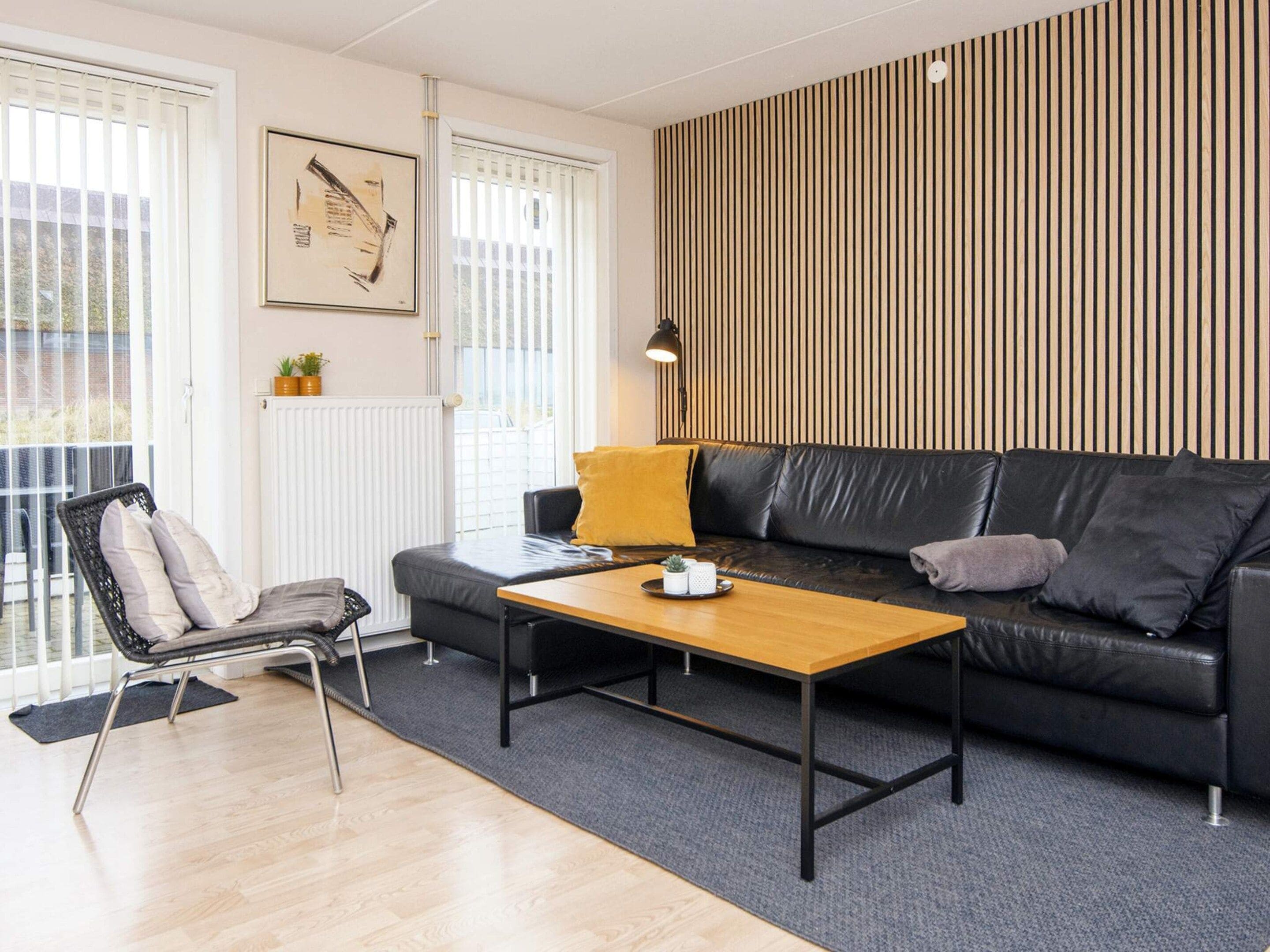 Ein modernes Wohnzimmer mit einer Couch, einem Couchtisch, einem Sessel und einer Heizung.