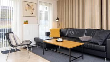 Ein modernes Wohnzimmer mit einer Couch, einem Couchtisch, einem Sessel und einer Heizung.