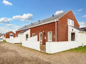 A row of single-story brick houses with white siding, each with a small front porch and a door. - 4 Star Holiday Home in Romo (Rømø)