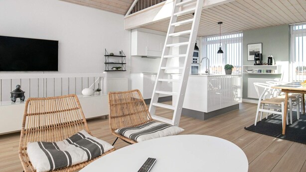 Een modern loft appartement met een slaapverdieping, een keuken en een eethoek.