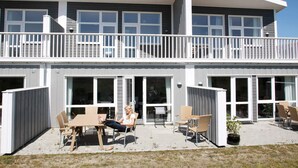 Een gebouw met twee verdiepingen, een balkon en grote ramen.