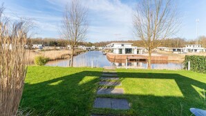 A modern residential area with a pond, pathways, and houses. - Amazing Villa in Zeewolde With Terrace (Zeewolde)