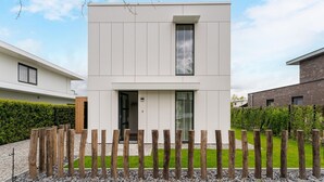 A modern two-story house with a flat roof, a central entrance, and a small balcony. - Amazing Villa in Zeewolde With Terrace (Zeewolde)