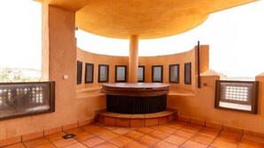 Un jacuzzi circulaire doté d’un sol carrelé et de murs avec des fenêtres verticales.