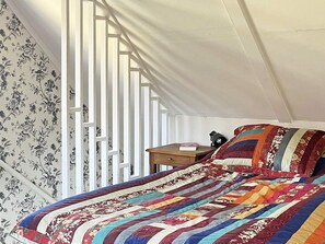 A bedroom with a bed, a nightstand, and a window with white blinds. - 6 Person Holiday Home in Klintehamn (Klintehamn)