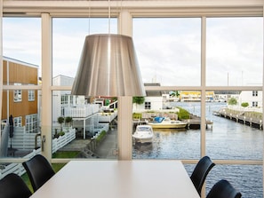 Un interior moderno con vistas a un puerto deportivo a través de amplios ventanales.