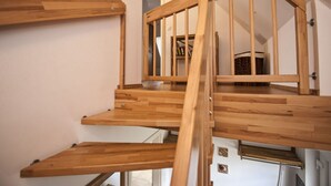 A wooden staircase with a handrail, leading to an upper floor. - Nice Apartment in Zempin (Zempin)