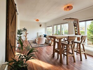 A spacious dining area with wooden furniture and a view of the outdoors. - Beautiful Holiday Home With Spacious Garden (Voorthuizen)