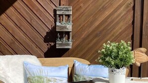 A wooden deck with a wooden bench and a small table. - Holiday Apartment Meerzeit (Brodersby)