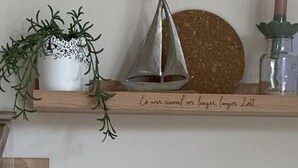 A wooden table with a yellow candle holder, a knife, and a cutting board. - Holiday Apartment Meerzeit (Brodersby)