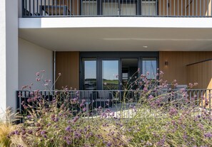 A modern apartment with a balcony, outdoor seating, and a view of the landscape. - Modern Apartment With Harbour View in Kamperland (Kamperland)