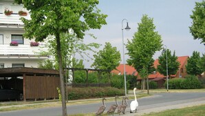 A residential street with a row of houses, a parked car, and a pedestrian walkway. - Holiday Apartment With Castle View (Wernigerode)