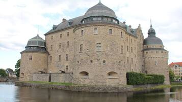 A historic stone building with multiple domes and a moat.