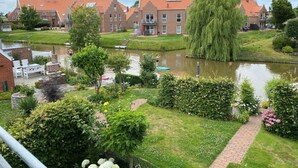 Et boligområde med en kanal, murstenshuse og et salgetræ.
