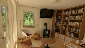 A cozy living room with a large bookshelf, a fireplace, and a television. - Holiday Home Werder/havel (Werder (Havel))
